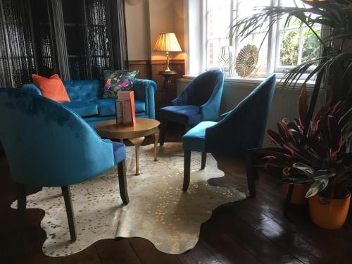 a living room with blue chairs and a blue couch at Virginia Court Hotel in Cromer