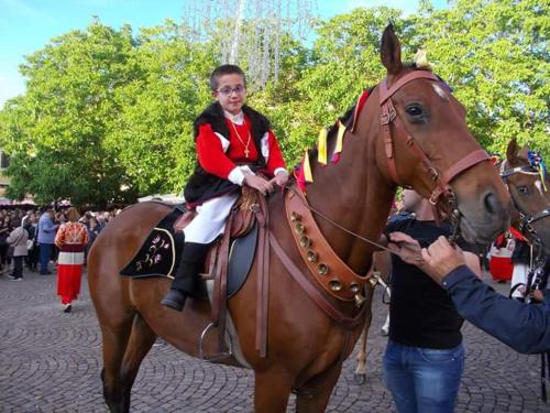 a young child riding on the back of a horse at B&b Gennargentu in Fonni