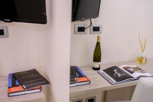a table with books and a bottle of wine at Domus Il Palio in Siena