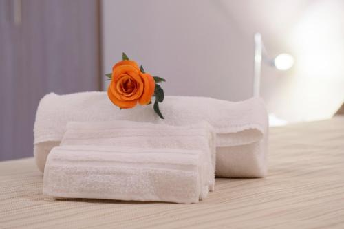 a flower sitting on top of towels on a bed at Domus Il Palio in Siena