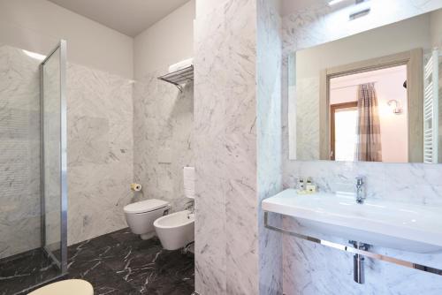 a bathroom with a sink and a toilet and a mirror at Domus Il Palio in Siena