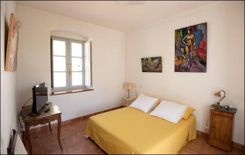 um quarto com uma cama amarela e uma janela em Villa Lazaret em Ajaccio