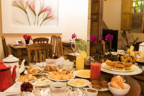 een tafel met borden eten erop bij Pousada Encanto da Serra in Tiradentes
