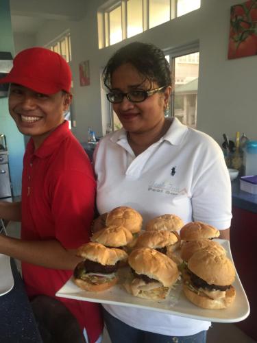 a woman holding a tray of sandwiches on a plate at Joah Inn Appartementen in Paramaribo