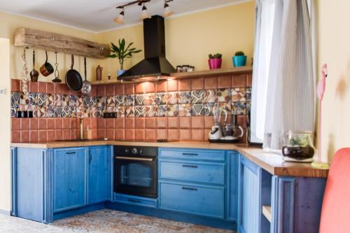 a kitchen with blue cabinets and tiles on the wall at Amazing 5 bedroom house KRUMLOV 82 - 4 min walk to main square in Český Krumlov