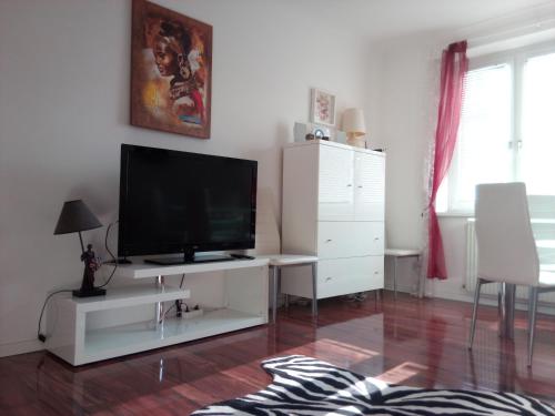 a living room with a flat screen tv on a white cabinet at Apartment Paradies - U1 Station altes Landgut in Vienna