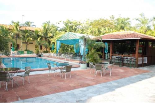 a patio with tables and chairs next to a pool at Mariá Plaza Hotel in Araçatuba