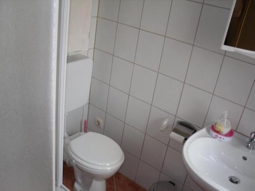 a white bathroom with a toilet and a sink at Hotel Zur Rose in Bad Karlshafen
