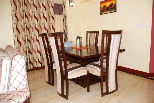 a dining room table and chairs in a room at Kigali Village Suites in Kigali