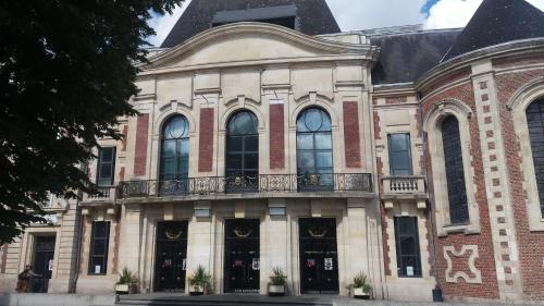 a large brick building with a balcony on it at Apt 6 du Temple 2 chambres & Parking in Cambrai