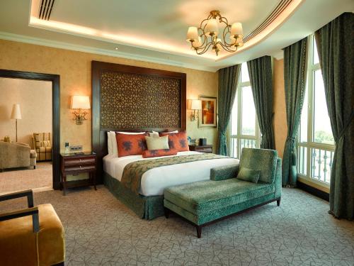 a large hotel room with a bed and a chair at Royal Maxim Palace Kempinski Cairo in Cairo