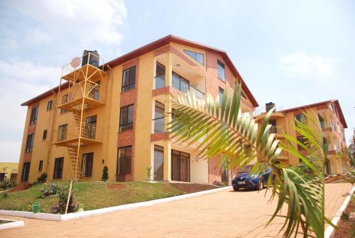a building with a palm tree in front of it at Kigali Village Suites in Kigali