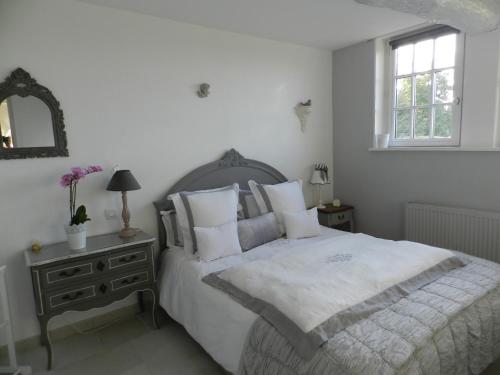 a bedroom with a white bed and a window at Le Pressoir in Beuvron-en-Auge