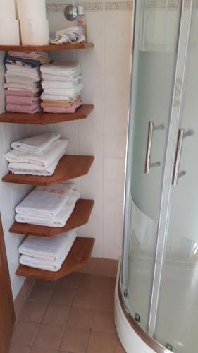 a bathroom with a shower and a stack of towels at Valun Seaside Apartments in Valun