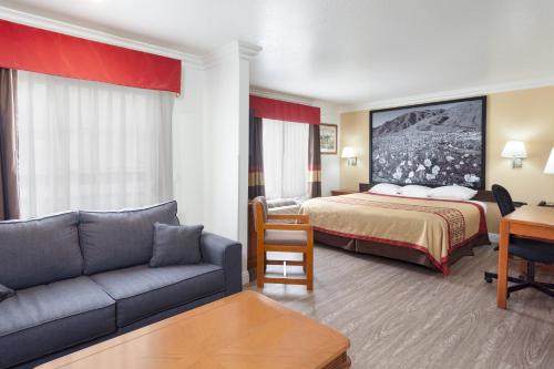 a hotel room with a bed and a couch at Super 8 by Wyndham Santa Clarita/Valencia in Santa Clarita