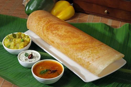 un rollo de pan sobre una hoja de plátano con tazones de sopa en Hotel Pariwar, en Aurangabad