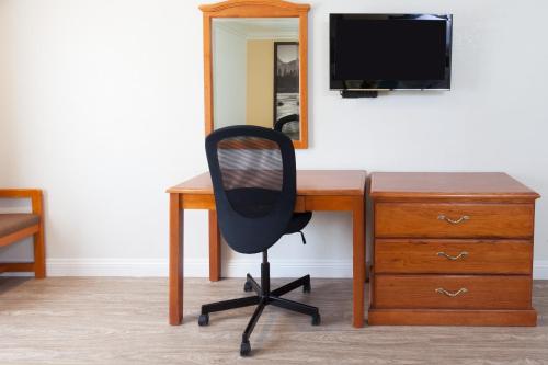 a desk with a chair and a television and a mirror at Super 8 by Wyndham Santa Clarita/Valencia in Santa Clarita
