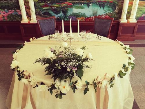 a white table with flowers and candles on it at Hotel Lido - Beach and Palace in Bolsena