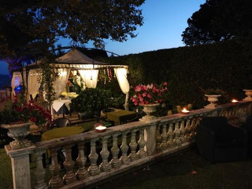 a garden with a fence and a gazebo with lights at Hotel Lido - Beach and Palace in Bolsena