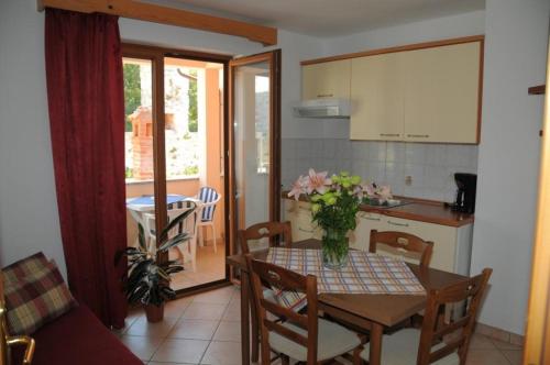 una cocina y una mesa con un jarrón de flores. en Villa Radovan, en Novigrad Istria