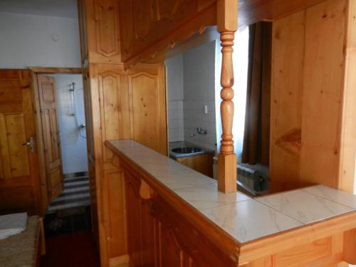 cocina con armarios de madera y encimera en Damianka Guest House, en Bansko