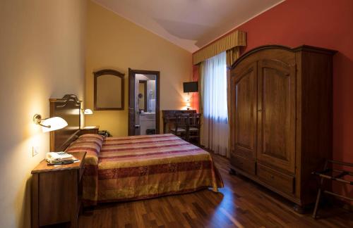 1 dormitorio con 1 cama y 1 mesa con lámpara en La Torre Ai Mari en Sarteano