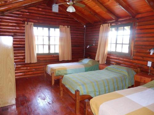 A bed or beds in a room at Las Cortaderas Cabañas de Tronco