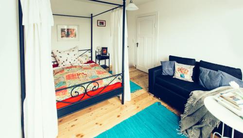 a bedroom with a bed and a couch at Das Blaue Haus in Husum