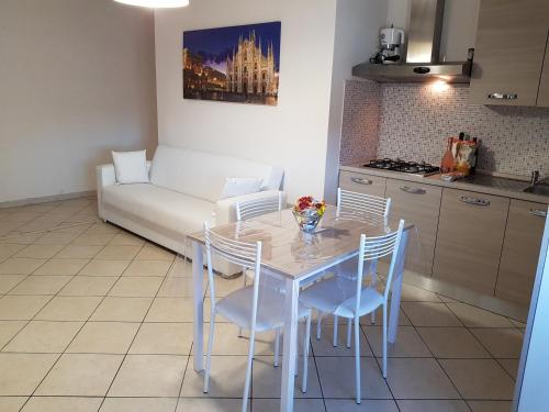 una cucina con tavolo, sedie e divano di Andrea's Apartments - Zanoli a Milano