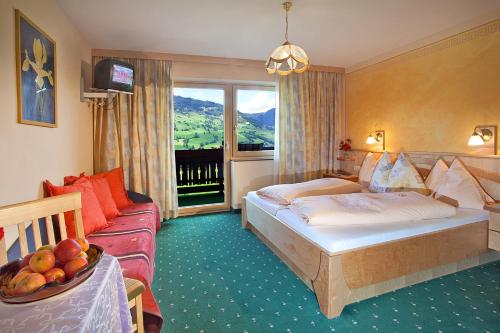 une chambre d'hôtel avec un lit et un canapé dans l'établissement Pension Schwab, à Taxenbach