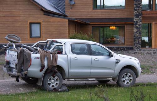 a white truck parked in front of a house at Lago Rosario Lodge in Trevelin