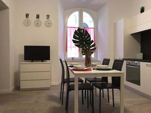 cocina con mesa con sillas y TV en Casa Ohana, en Ancona