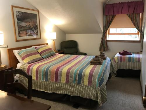 a hotel room with a bed and a chair at 7 Gables Inn & Suites in Fairbanks
