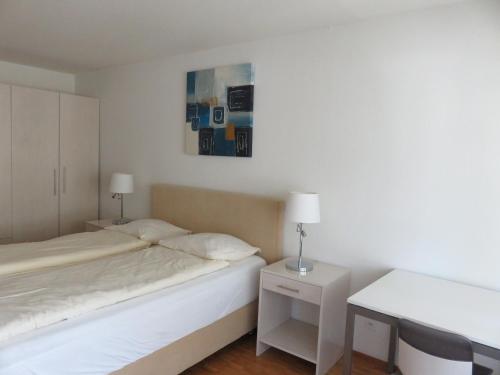 a bedroom with two beds and a table and a picture at Swiss Star District 11 - Self Check-In in Zürich
