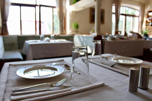 a table with plates and utensils on top of it at Penzion & Wellness Zoborska in Nitra