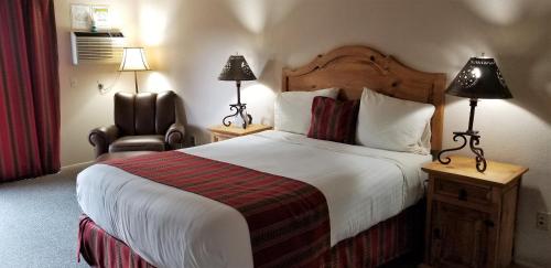 a hotel room with a large bed and a chair at Beaver Creek Inn in Lake Montezuma