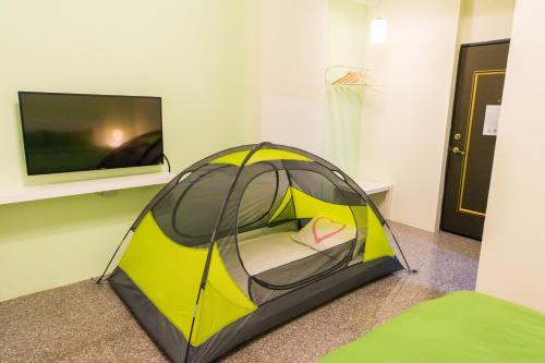 a yellow and black tent in a room with a tv at Nice Guanxi in Guanxi