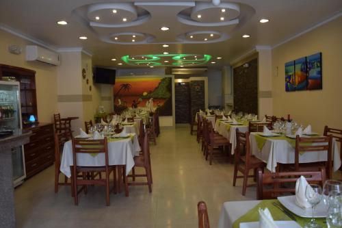 a dining room with tables and chairs in a restaurant at Hotel Perla Verde in Volcán Chimborazo