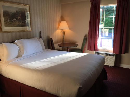 a large white bed in a hotel room at Kirkwood Inn in Mason