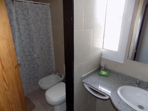 a bathroom with a toilet and a sink at Cabañas Plaza Norte in San Martín