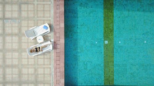 an overhead view of a swimming pool with people in chairs at Royal Benja Hotel - Big Room Family-Friendly in Bangkok