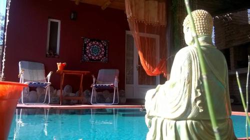 una estatua sentada junto a una piscina en Amaltea en Villa Las Rosas