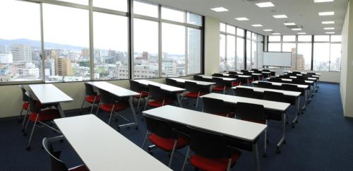 an empty classroom with desks and chairs and windows at Kurume Hotel Esprit in Kurume