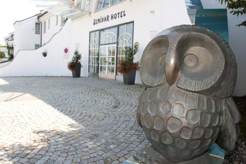 a statue of an owl sitting on a street at Seminarhotel Göttlesbrunn in Göttlesbrunn