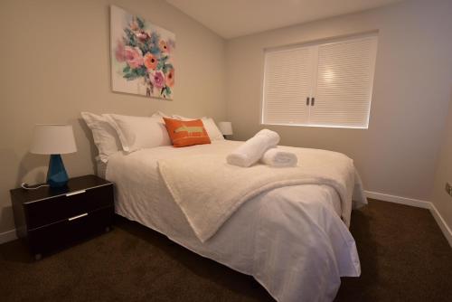 een slaapkamer met een bed en een raam bij Epsom Apartments in Auckland