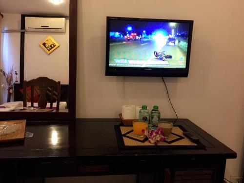 a living room with a tv on a wall with a table at Vientiane SP Hotel in Vientiane