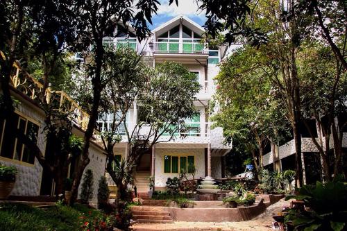 a large white house with stairs and trees at Rao Ga Khao Resort in Mu Si