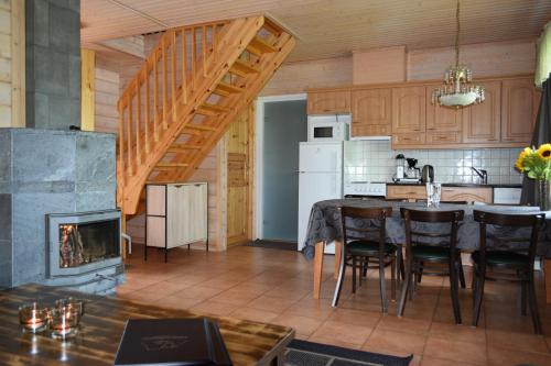 a kitchen and dining room with a table and a fireplace at Kilpisjärven Tunturimajat in Kilpisjärvi