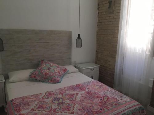 a bedroom with a bed with a pillow and a window at Domus Valencia Apartamentos Loft zona Pechina in Valencia