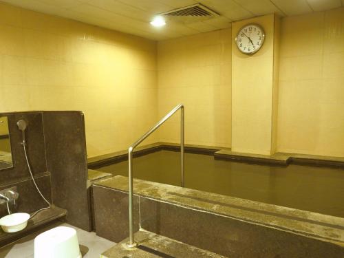 a bathroom with a tub and a clock on the wall at Dia Park Premier in Gurgaon